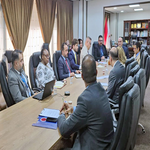 Group of professionals seated around a long conference table in a formal meeting room with a Turkish flag visible in the background   جامعة الرافدين   مدير الموقع عمار محمود ابو الشعير   جامعة الرافدين   مدير الموقع عمار محمود ابو الشعير