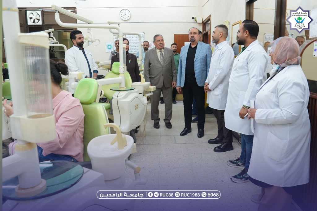 DSC00131 1 جامعة الرافدين 2026 Group of professionals in white coats and suits touring a dental clinic with green chairs and dental units university logo visible in the corner جامعة الرافدين مدير الموقع عمار محمود ابو الشعير