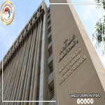 Tall beige government building with Arabic signage on the façade and an official round emblem in the upper left   جامعة الرافدين   مدير الموقع عمار محمود ابو الشعير   جامعة الرافدين   مدير الموقع عمار محمود ابو الشعير