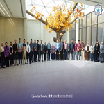 Group of about 40 people posing for a photo in a bright hallway with a yellow leaved tree centerpiece   جامعة الرافدين   مدير الموقع عمار محمود ابو الشعير   جامعة الرافدين   مدير الموقع عمار محمود ابو الشعير